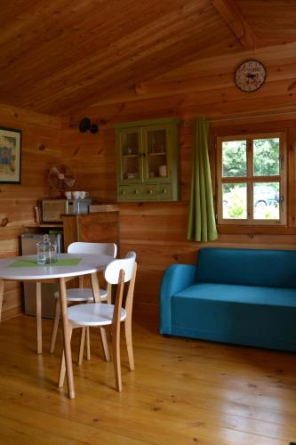 un salon avec un canapé bleu et une table dans l'établissement Le Jardin des Pierres Brunes, à Saint-Jean-des-Ollières