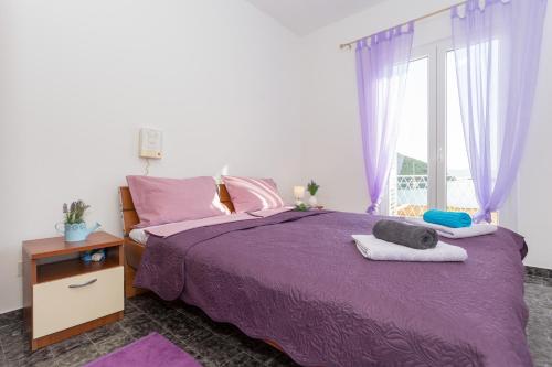 a bedroom with a purple bed and a window at Nono Frano in Prožura