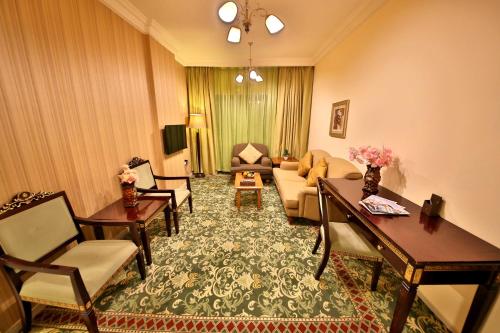 a living room with a couch and chairs at Midtown Furnished Apartments in Ajman 