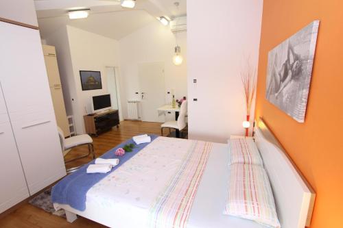 a bedroom with a bed with an orange wall at Apartments Tanja in Rovinj
