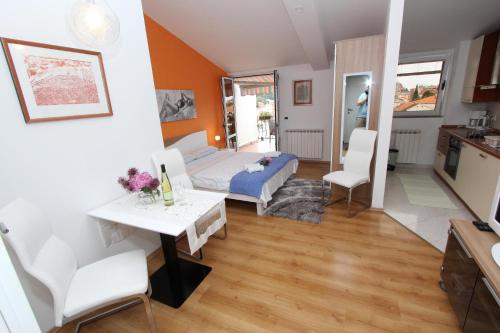 a bedroom with a bed and a table and chairs at Apartments Tanja in Rovinj