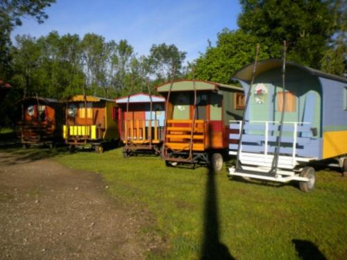 a group of old train cars parked in a field at Che'Val d'Amour in Écleux