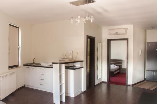 uma cozinha com armários brancos e uma bancada em Vila La Mer em Eforie Nord