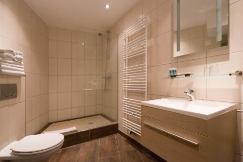 ein Bad mit einem WC, einem Waschbecken und einer Dusche in der Unterkunft Auberge De L'Our in Vianden