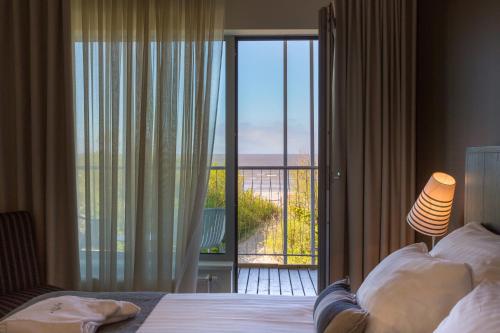 a bedroom with a bed and a view of a balcony at Hedon Spa & Hotel in Pärnu