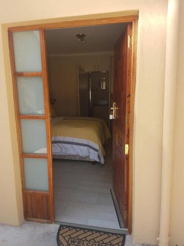 a door to a bedroom with a bed in it at LightStone Guesthouse in Centurion