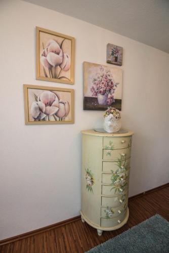 a room with a dresser and paintings on the wall at Ferienwohnungen Rexha in Schwangau