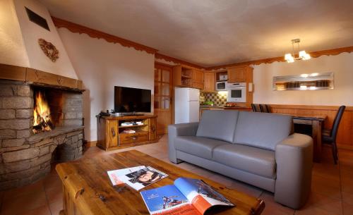 een woonkamer met een bank en een open haard bij Chalet des Neiges Plein Sud in Val Thorens