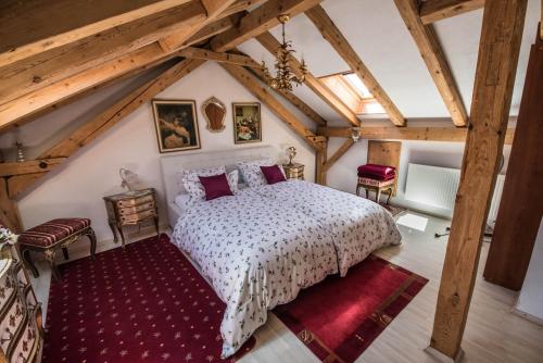 an attic bedroom with a white bed and red rug at Ferienwohnungen Rexha in Schwangau