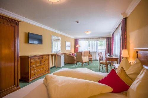 a hotel room with a bed and a living room at Sporthotel Austria in Sankt Johann in Tirol