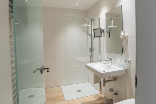 a bathroom with a sink and a shower at Brennereihotel Sponsel in Kirchehrenbach