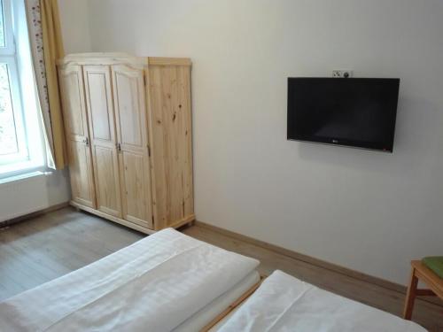a room with a bed and a tv on a wall at Gasthaus Wagner in Golzow