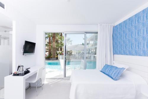 a white hotel room with a bed and a tv at Reverence Mare Hotel - Adults Only in Palmanova