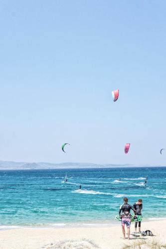 a group of people on the beach flying kites at Orkos Beach Hotel in Mikri Vigla