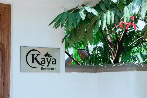 a sign on a wall with a plant on it at Kaya Residence Kandy in Kandy