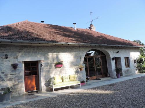 a stone house with a couch on the porch at Che'Val d'Amour in Écleux