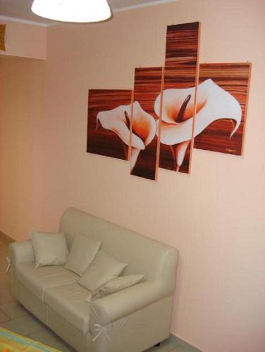a living room with a couch and paintings on the wall at B&B Il Gabbiano in Reggio Calabria