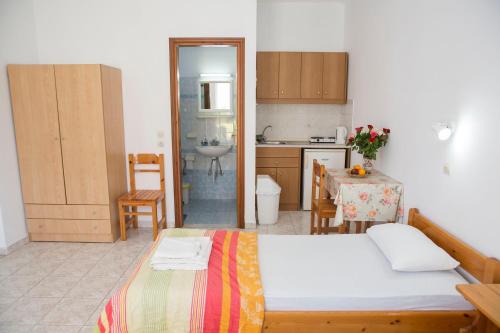 a bedroom with a bed and a kitchen with a table at Haraki View in Haraki