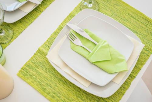 a table with a white plate with a fork and napkin at Panorama+ in Almirida