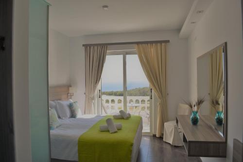 a bedroom with a bed and a large window at Lefkorama in Lefkos Karpathou