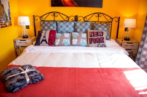 a bedroom with a bed with a red and white comforter at Casa Rural Collarubio in Collado Mediano