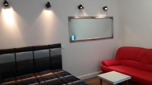 リヴィウにあるApartment with fireplaceのリビングルーム(赤いソファ、鏡付)