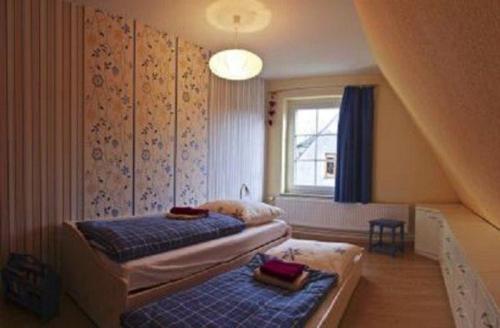 1 dormitorio con 2 camas y escalera en Ferienhaus-Landmann, en Tannenberg