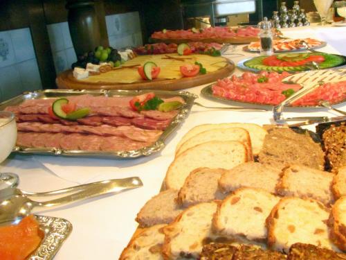 a table topped with different types of meats and bread at Gästehaus Kristall in Kleinarl