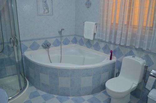 a bathroom with a tub and a toilet and a shower at The April Maisonette in Marsaskala
