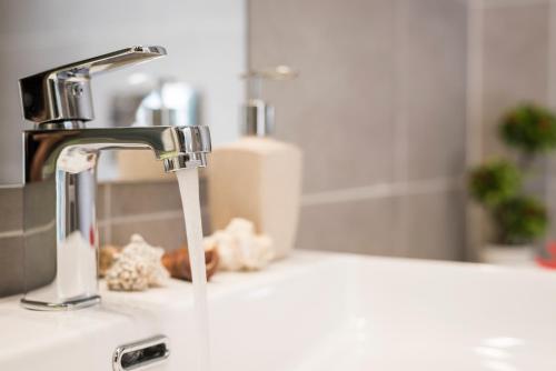a sink with a faucet in a bathroom at Panorama+ in Almirida