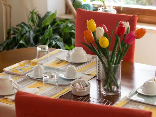 a table with a vase of flowers on a table at sopra al FORTE in Querceta