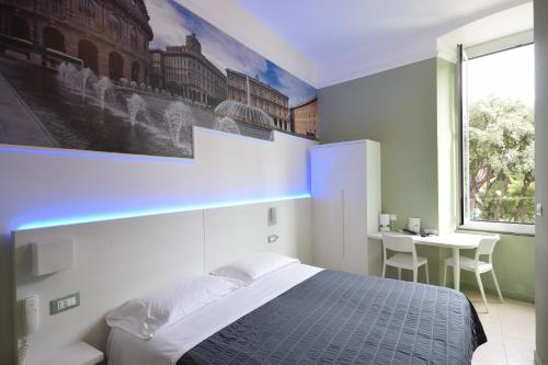 a bedroom with a bed and a desk and a window at Hotel Fiume in Genoa
