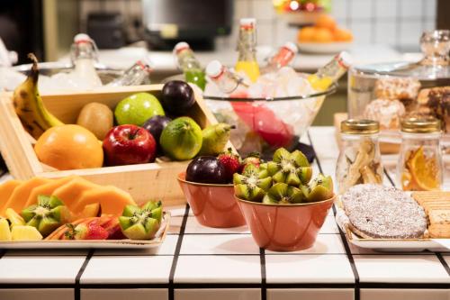 a counter topped with bowls of fruits and vegetables at The Corner Hotel in Barcelona