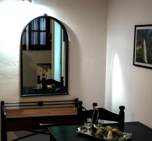 a dining room with a table and a mirror at Christina Perlia Studios in Poros