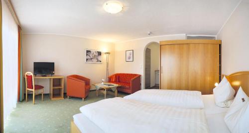 a hotel room with two beds and a desk at Im Gewölbe in Bad Füssing