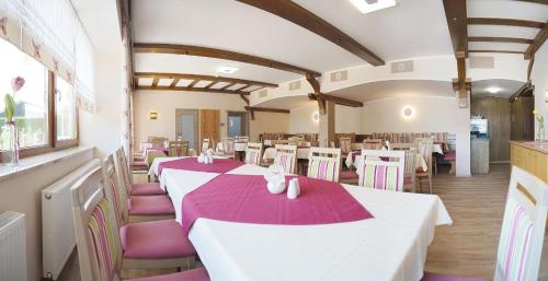 uma sala de jantar com mesas brancas e cadeiras roxas em Im Gewölbe em Bad Füssing