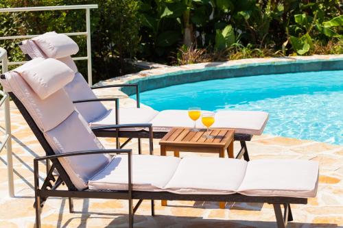 a couple of chairs and a table next to a pool at Relax tiny villas 40 meters of the beach in Korčula