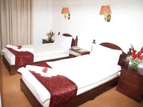 a hotel room with two beds with red accents at Evergreen Hotel in Antananarivo
