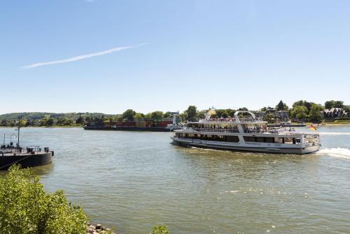 two boats traveling down a river with at Maritim Hotel Königswinter in Königswinter