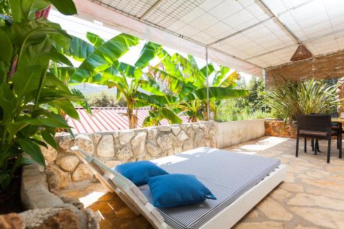 a bed with two blue pillows on a patio at Relax tiny villas 40 meters of the beach in Korčula