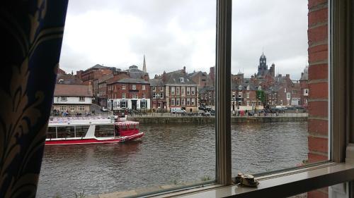 a window view of a boat in a river at The Queens Hotel & Victoria Cloisters Apartments in York