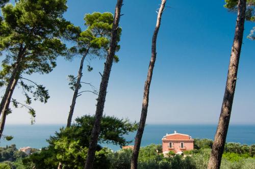 ein Haus durch die Bäume vor dem Meer in der Unterkunft I Frangiventi in Rodi Garganico