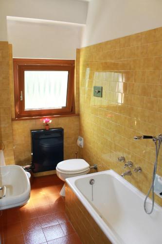 a bathroom with a tub and a toilet and a sink at Hotel Miramonti in Chiesa in Valmalenco