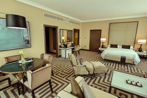 a hotel room with a bed and a table and chairs at Al Maha Arjaan by Rotana in Abu Dhabi