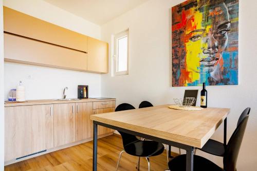 a kitchen with a wooden table and a painting on the wall at VilaA21 in Bar