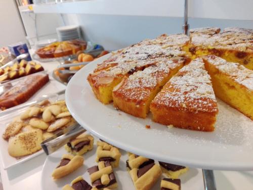 リッチョーネにあるHotel Ermeti B&B Brunchのテーブルの上に置かれたパンとその他のペストリーの皿