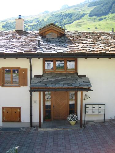 a house with a wooden door and a roof at Dachwohnung Unterem Hoereli in Vals