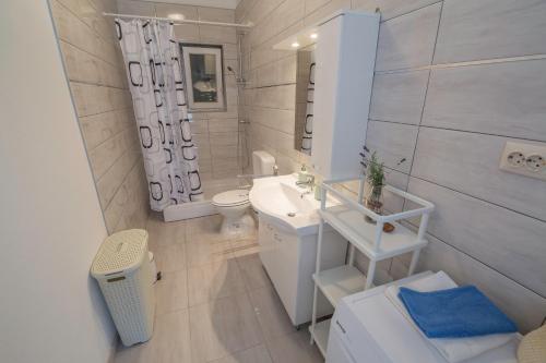 a white bathroom with a sink and a toilet at Apartments Mediterano in Senj