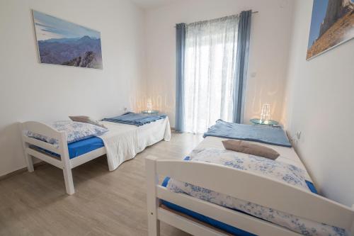 a bedroom with two beds and a window at Apartments Mediterano in Senj