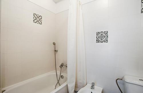 a bathroom with a white tub and a toilet at BmyGuest - Ericeira Terrace Apartment in Ericeira